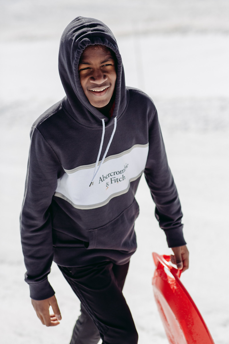 boy walking with sled on glacier